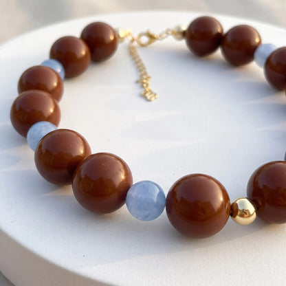Robyn by design beaded statement necklace with glossy chocolate brown and translucent periwinkle blue beads and gold hardware